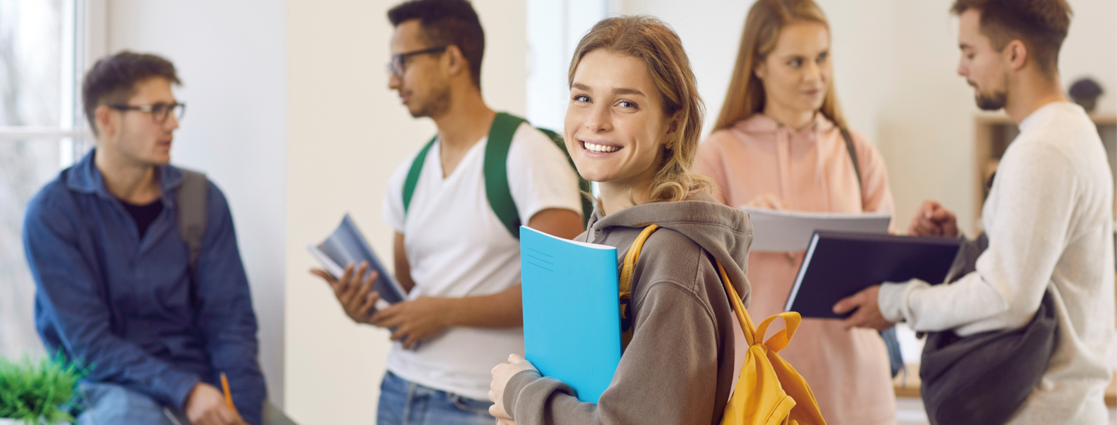 Application example in schools, a group of students together with one girl holding her school books and smiling towards the camera